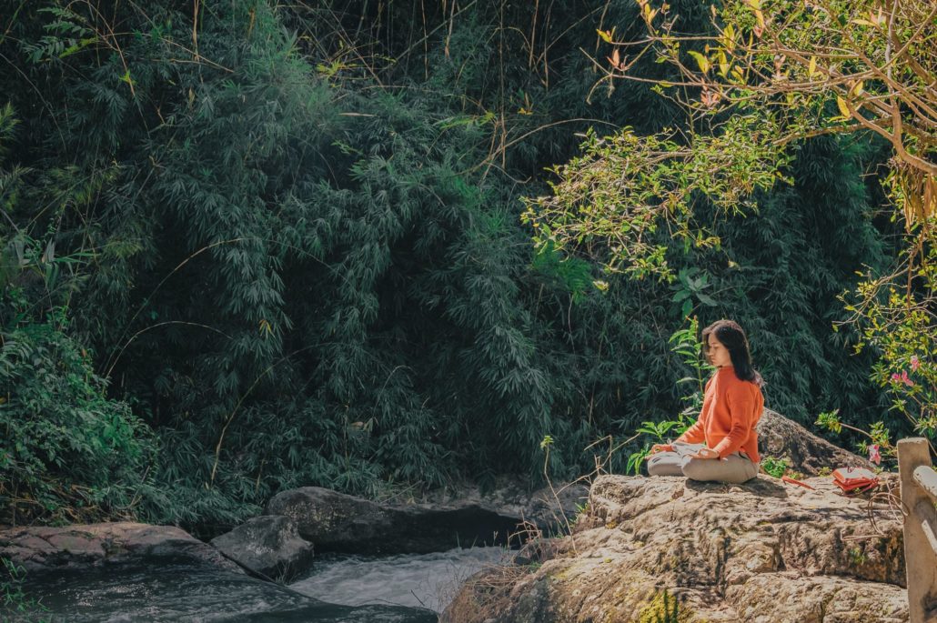 Frau in der Natur findet sich selbst durch Meditation